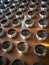 Row of silvery alms bowls with little coins inside in buddhist temple