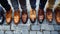 A row of sleek, polished mens shoes in various shades, lined up neatly in a symmetrical formation