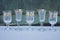 A row of small white glass crystal goblets