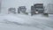 Row of Snow Plows clearing a highway during a snow storm