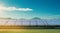 Row of solar panels tilted towards the sun with blue sky and clouds