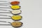 Row of spoons containing different spices powder. Clear space at right