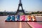 A row of sports shoes lined up on a track with France, Paris Eiffel tower in the background