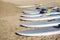 Row of stand up paddle boards resting on the beach ready to rent