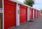 Row of storage garage units with red doors