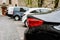 Row of at street side parked cars. View to the rear of cars