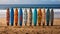 A row of surfboards sitting on top of a sandy beach