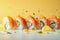 Row of sushi rolls with dynamic splashes and garnishes on a yellow background.