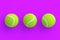 Row of three tennis balls on violet background