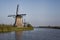 Row of traditional wind mills along blue canal in Kinderdijk