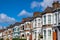 A row of typical British terraced houses in London with an estate agent sign