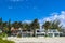 Row of vacation beach houses setting back from the public beach in a Mexican village with bright blue sky and palm trees blowing i