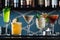 Row of various colourfull alcoholic cocktails on a bar desk. Glasses of differen shapes