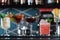 Row of various colourfull alcoholic cocktails on a bar desk. Glasses of differen shapes