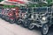 Row of vintage pedal-power four-wheeled surrey bike for rent on parking in public park. Rental station of retro quad bikes.