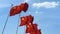 Row of waving flags of China agaist blue sky