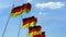 Row of waving flags of Germany agaist blue sky