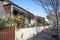 A row of weatherboard houses with Victorian-era wrought iron lacework and wooden fence in an Australian suburb.