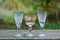 A row of white brown three glass crystal goblets on a gray wooden table