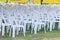 Row of white chairs plastic on lawn prepare business meeting