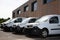 Row white delivery service van small trucks park front of factory warehouse distribution plant