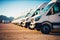 Row of white delivery trucks parked on top of dirt covered field with mountains in the background. Generative AI