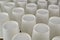 Row of white disposable eco friendly paper cup for coffee or hot beverage on dark backdrop. Selective focus