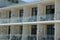 A row of white open glass balconies with furniture on the wall of the hotel