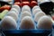 Row of white raw eggs display with selective focus for diet and health background.