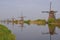 A row of windmill from front to back in kinderdijk with beautiful river water reflection