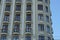 Row of windows with iron open balconies on the gray concrete wall