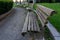 Row of wooden benches making curve in a park area. Diminishing perspective