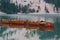 Row of wooden boats tied up in the middle of Lake Braies at first light in the morning
