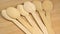 Row of wooden spoons on cutting board surface. Wooden eco-friendly disposable tableware rotate. Disposable ecological