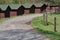 Row of wooden summer holiday cottages along dusty rural road in Czech countryside