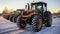 Row of yellow tractors on the snow covered field in the winter