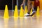 A row of Yellow Training Cones at Indoor Practice Field. Young Player on Training With Practice Trail