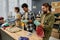 Row of young intercultural people sorting second hand clothes