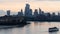 Rowboat floating on the tranquil waters of a river, in front of a stunning backdrop of skyscrapers