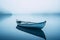 a rowboat sits on a calm lake in the fog