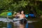 Rowers with oars in a canoe on rafting along the river in a summer sunny day. Friends are swimming in a boat. Leisure