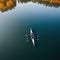 rowing on a calm lake in aerial view only small boat visible with serene water around vertical banner with copy space for