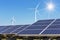 Rows array of polycrystalline silicon solar panels and wind turbines generating electricity in hybrid power plant systems station