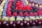 Rows of assorted fruits and berries: sweet cherry, bluberries, r