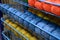 rows of balls of colorful cotton yarn threads for knitting blue, red and mustard colors on the shelves in the store.