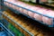 Rows of balls of colorful cotton yarn threads for knitting pale pink and mustard colors on the shelves in the store.