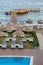 Rows of  beach umbrellas and loungers near poll  and pleasure pear in Aegean Sea