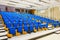 Rows of blue seats in lecture hall.