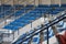Rows of blue, white ,red folding chairs in the football stadium