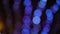 Rows of bokeh blue circles of light moving upwards on black background